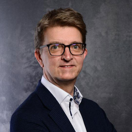 Frank Jüllich im Anzug und mit Brille.